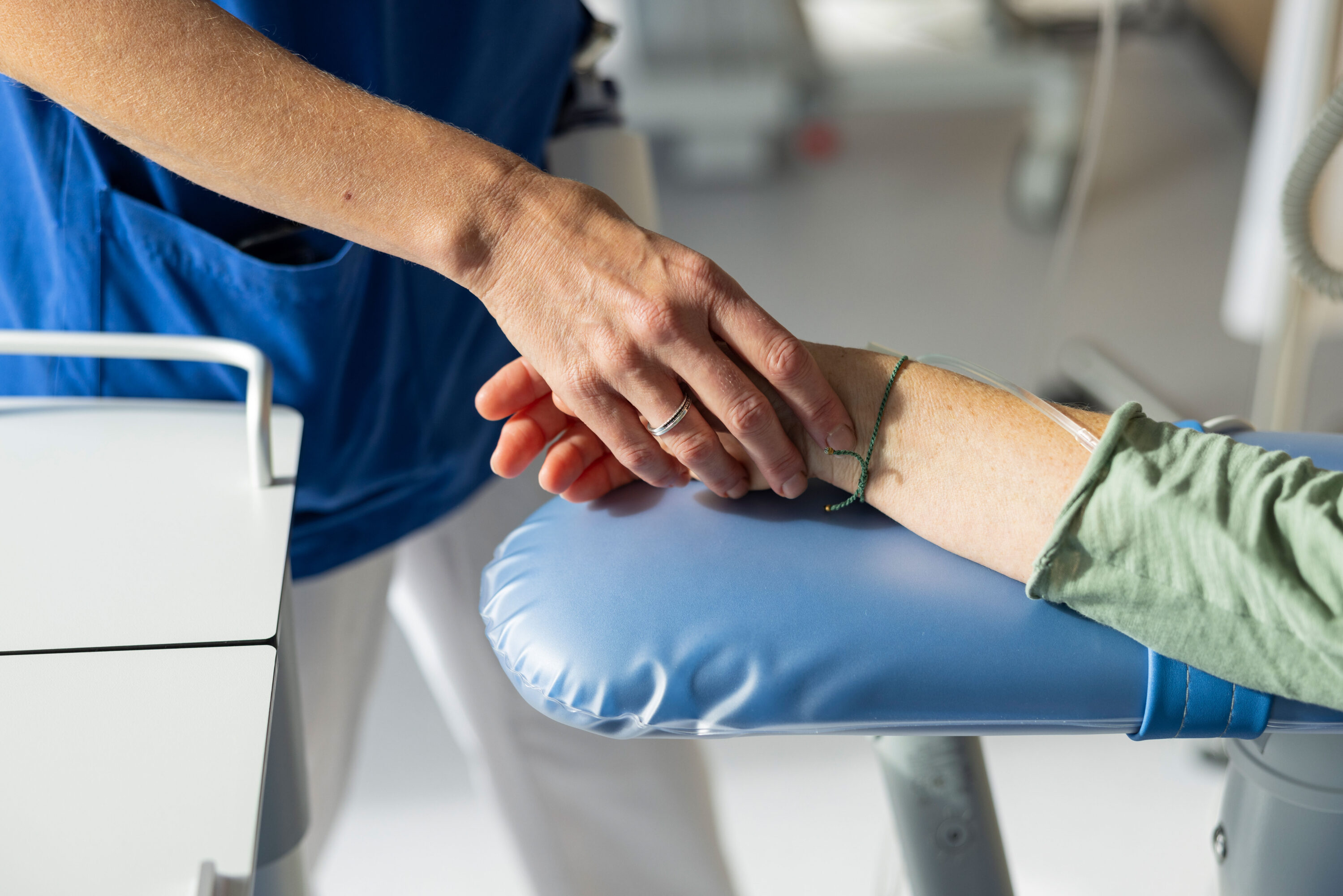 Pflegefachperson hält die Hand eines Patienten