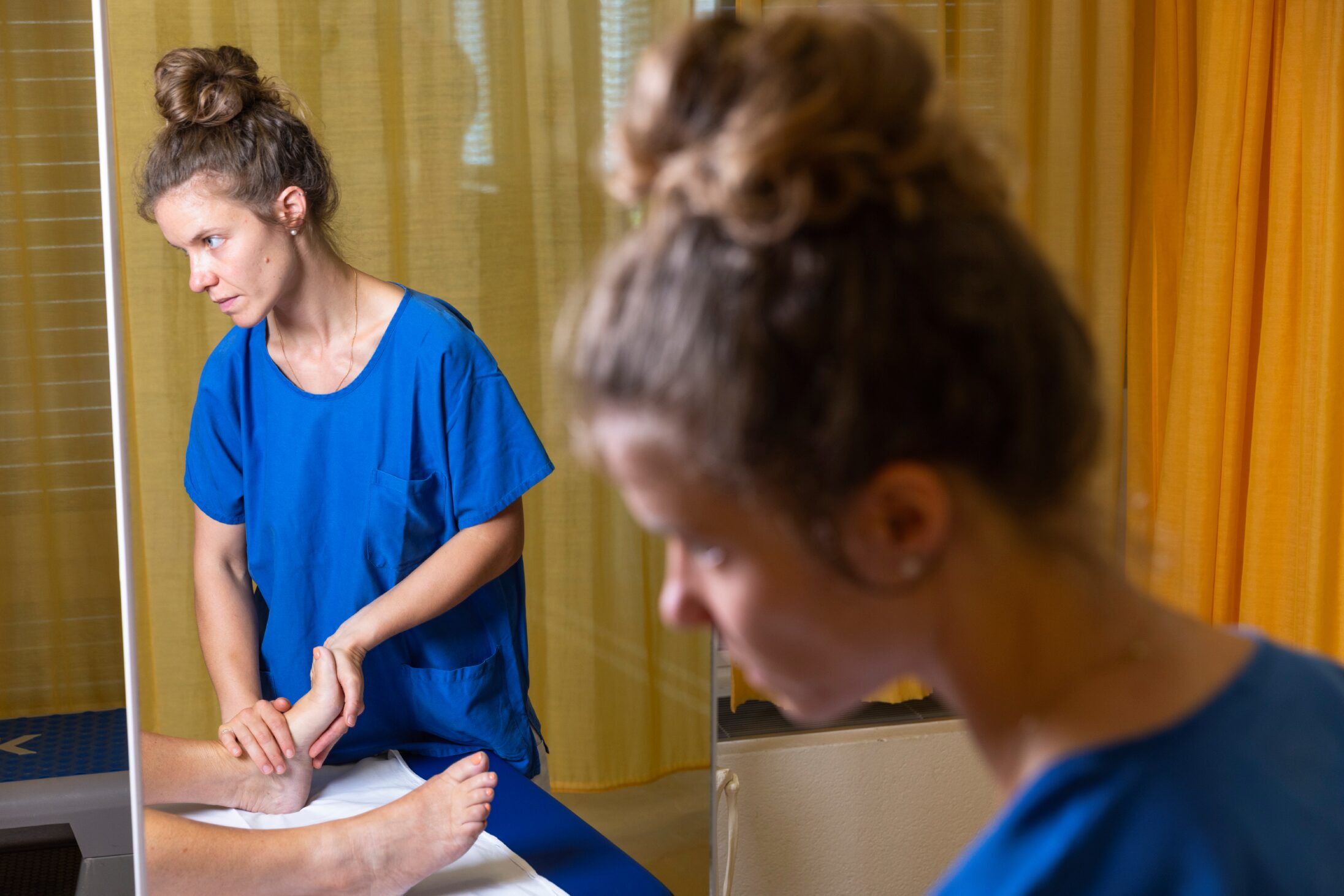 Physiotherapeutin behandelt den Fuss einer Patientin