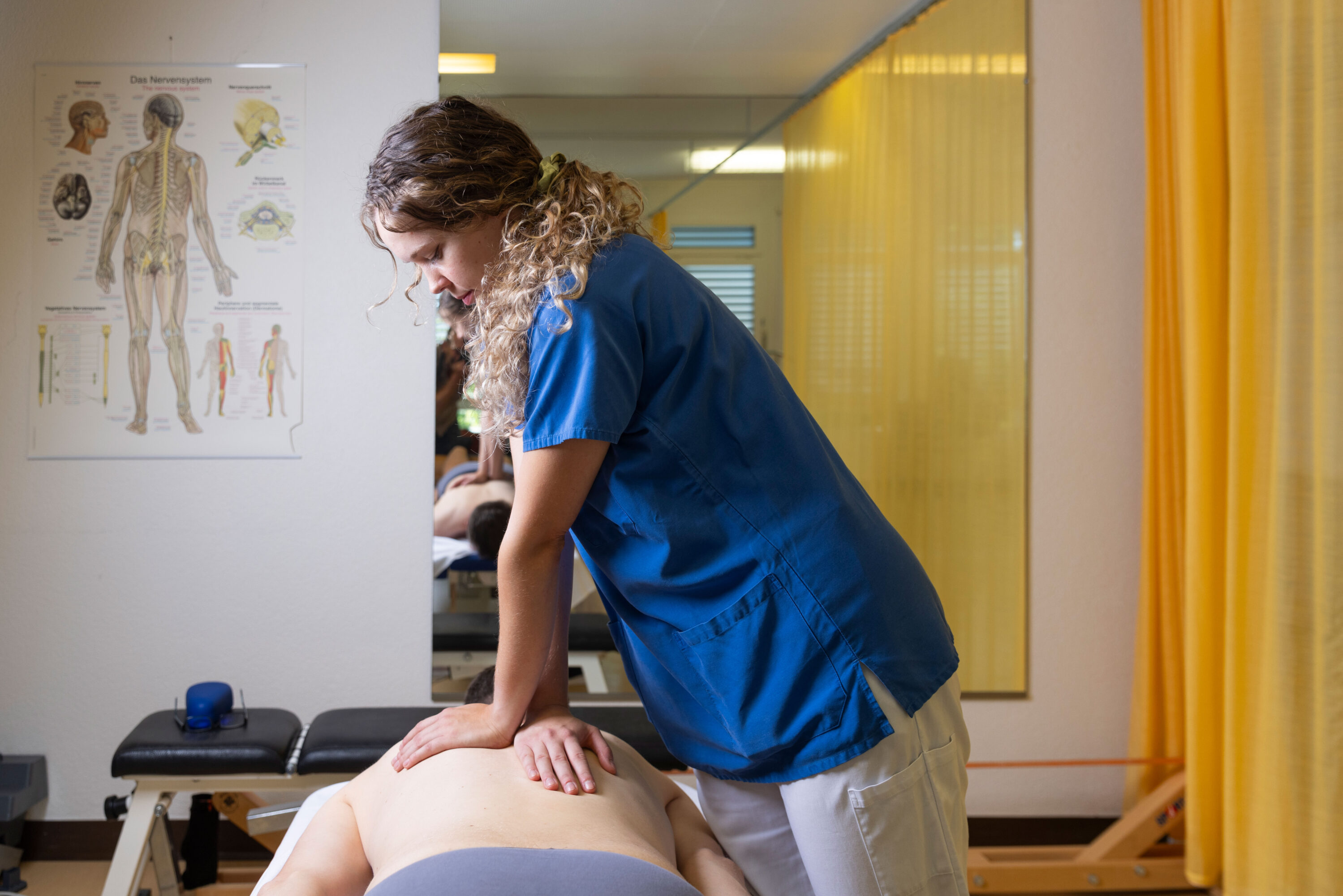 Physiotherapeutin behandelt den Rücken einer Patientin