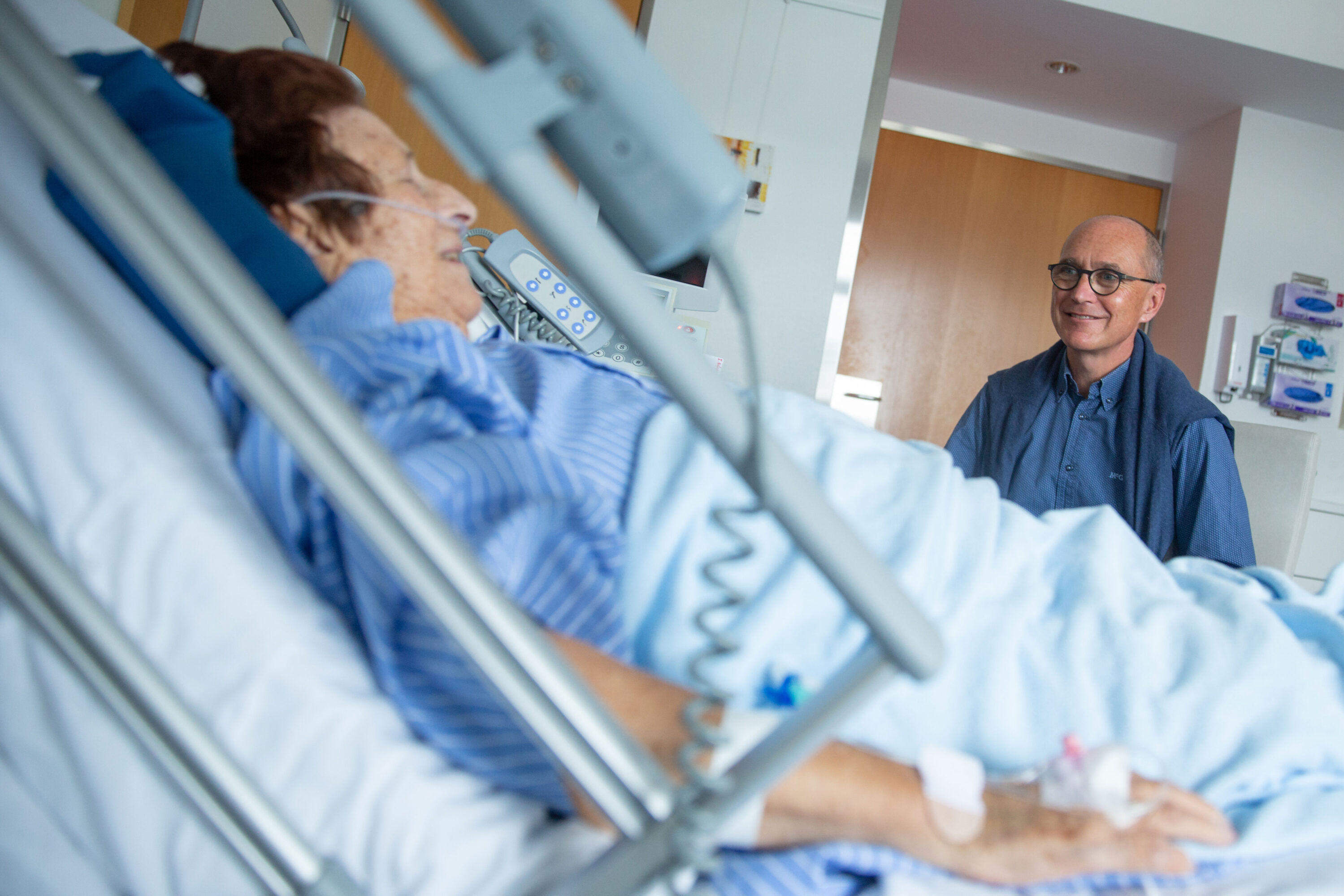 Seelsorger im Gespräch mit einer Patientin im Spitalbett